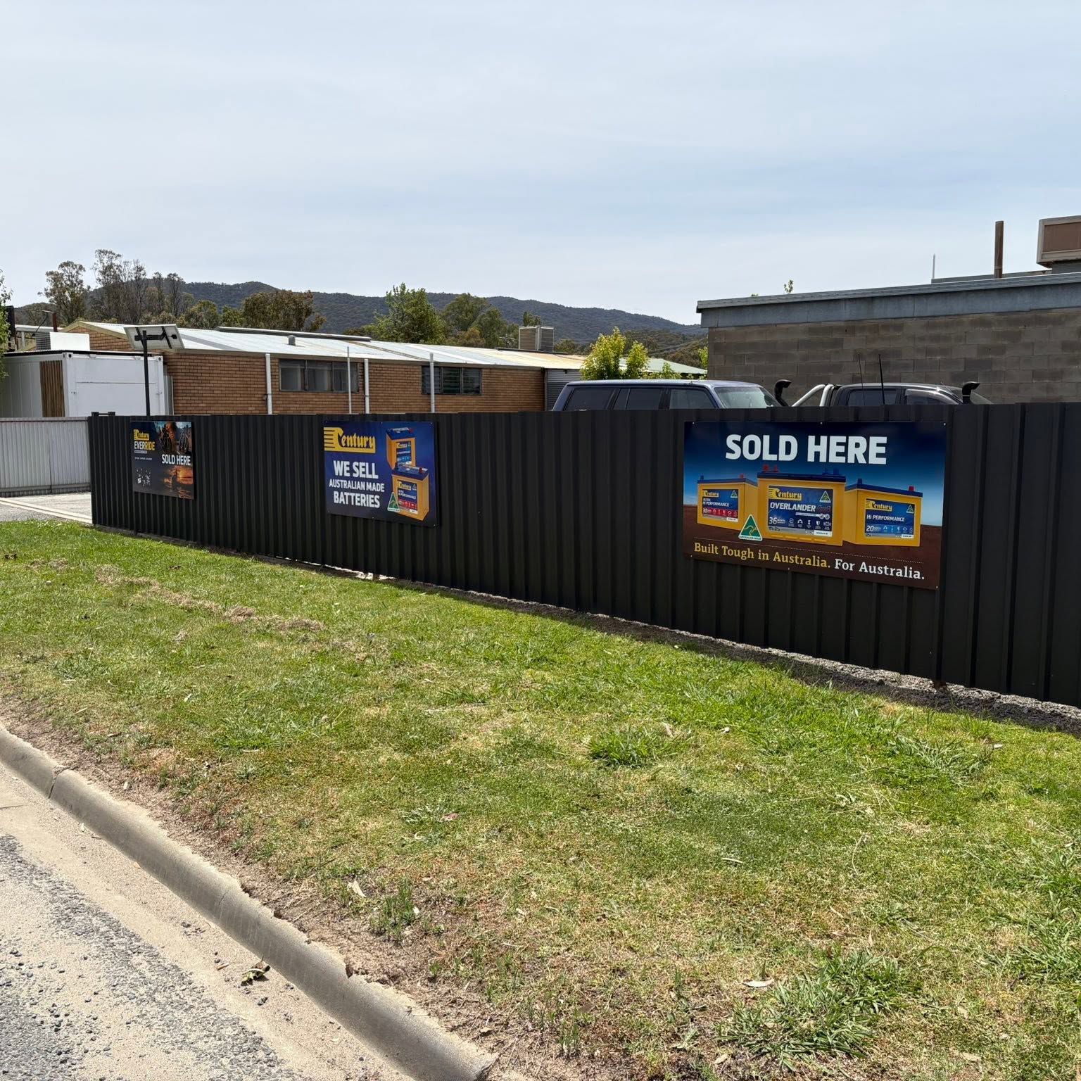 The Myrtleford Auto Electrics street frontage with Century Batteries banners and the Alpine hills behind