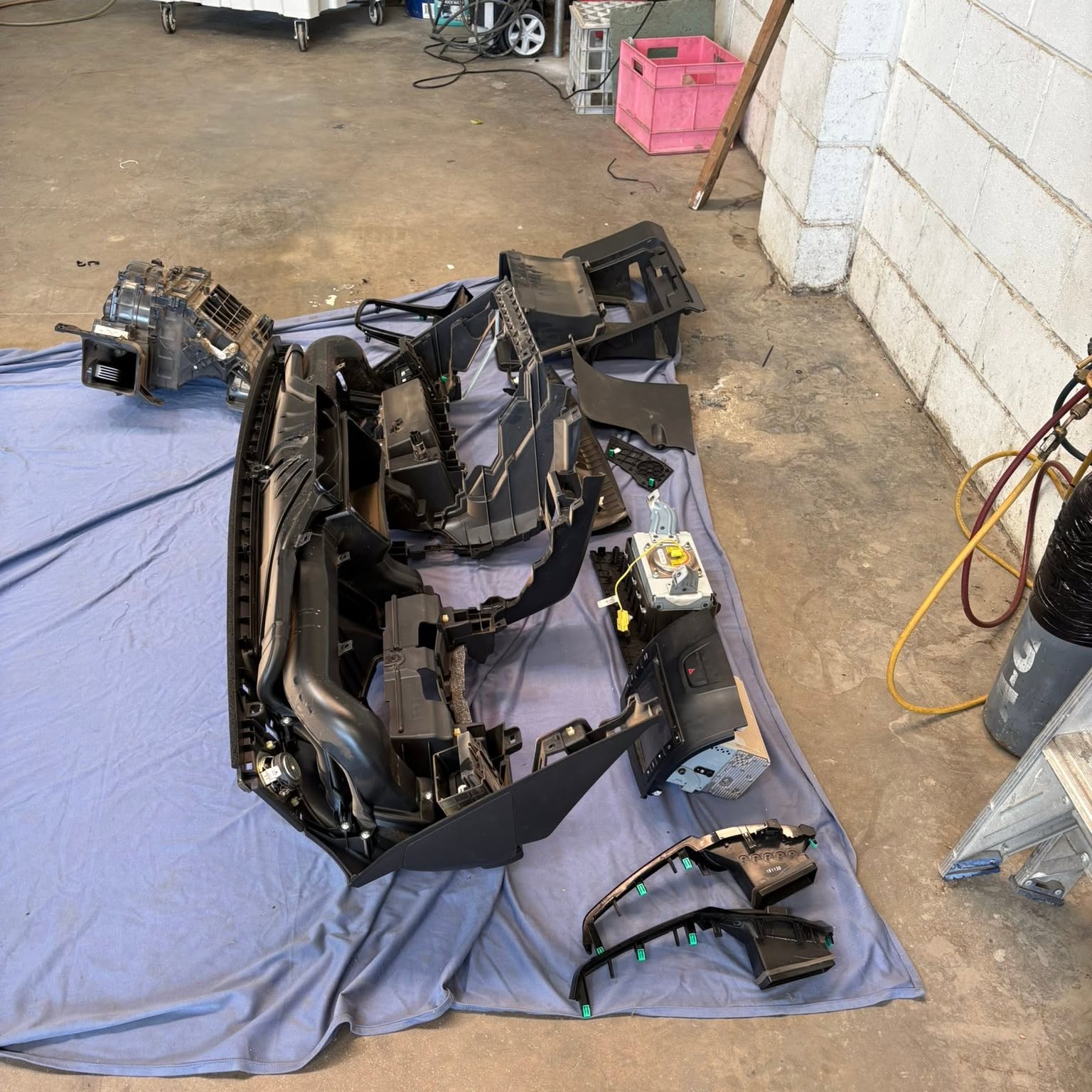 The complete dash assembly laid out in order on a drop sheet on the workshop floor