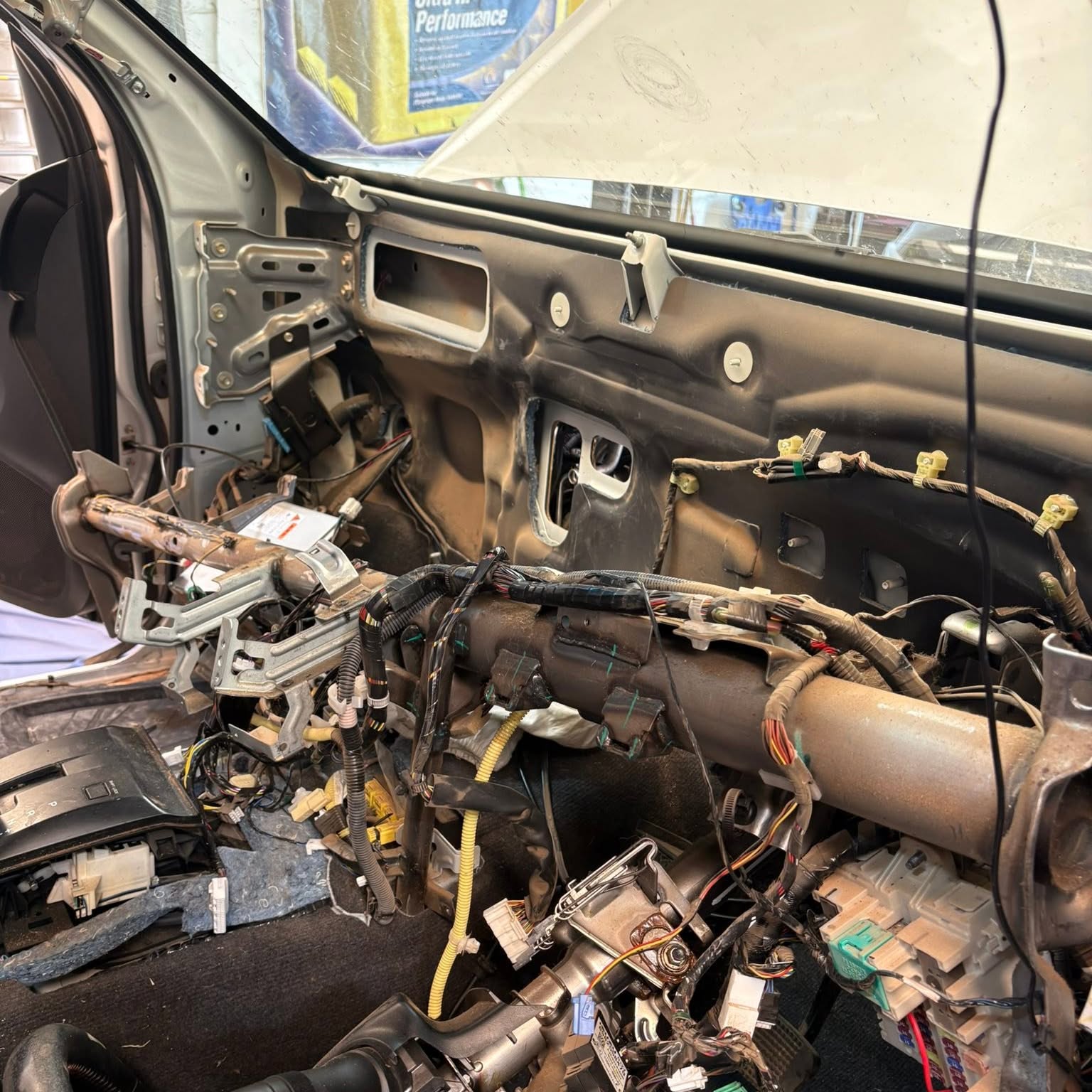 A ute with its dashboard removed, showing the bare firewall, wiring loom and steering column
